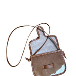 Brown and white cowhide crossbody bag on a white background.
