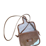 Brown and white cowhide crossbody bag on a white background.