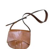 Close-up of a brown leather bag with visible stitching on a white background.