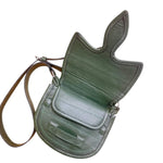 Green leather saddle bag with a strap on a white background. 