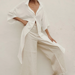 Woman wearing a white outfit with a plain background.