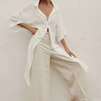 Woman wearing a white outfit with a plain background.