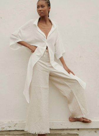 Woman wearing a white outfit with a plain background.