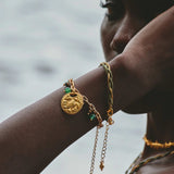 Woman wearing Refugio de Sol bracelet set with fossil jade and cat's eye stones.