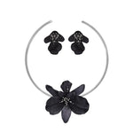 Black floral headband and earrings set on a white background