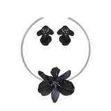 Black floral headband and earrings set on a white background