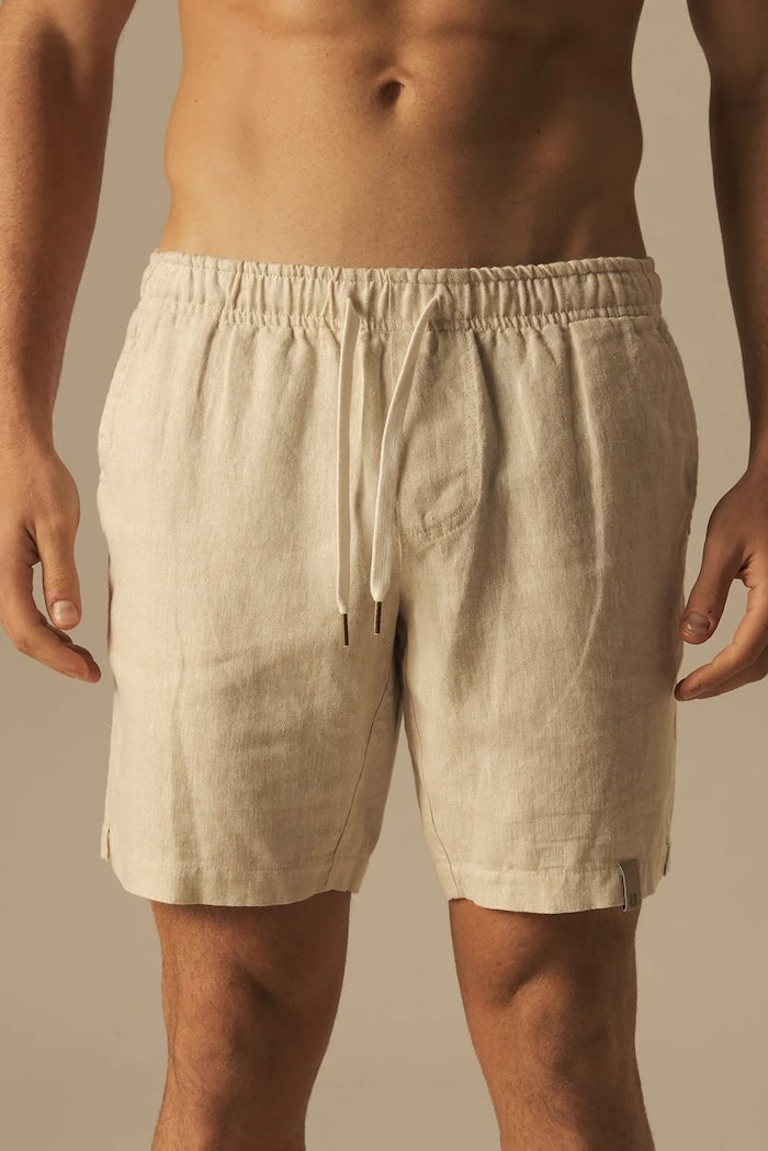 Beige shorts worn by a person on a beige background.