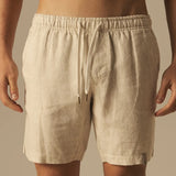 Beige shorts worn by a person on a beige background.