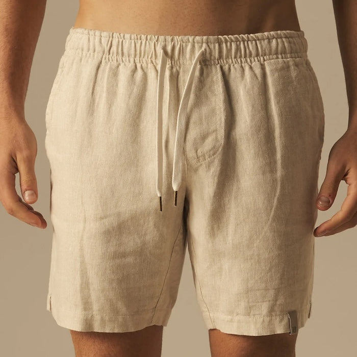 Beige shorts worn by a person on a beige background.