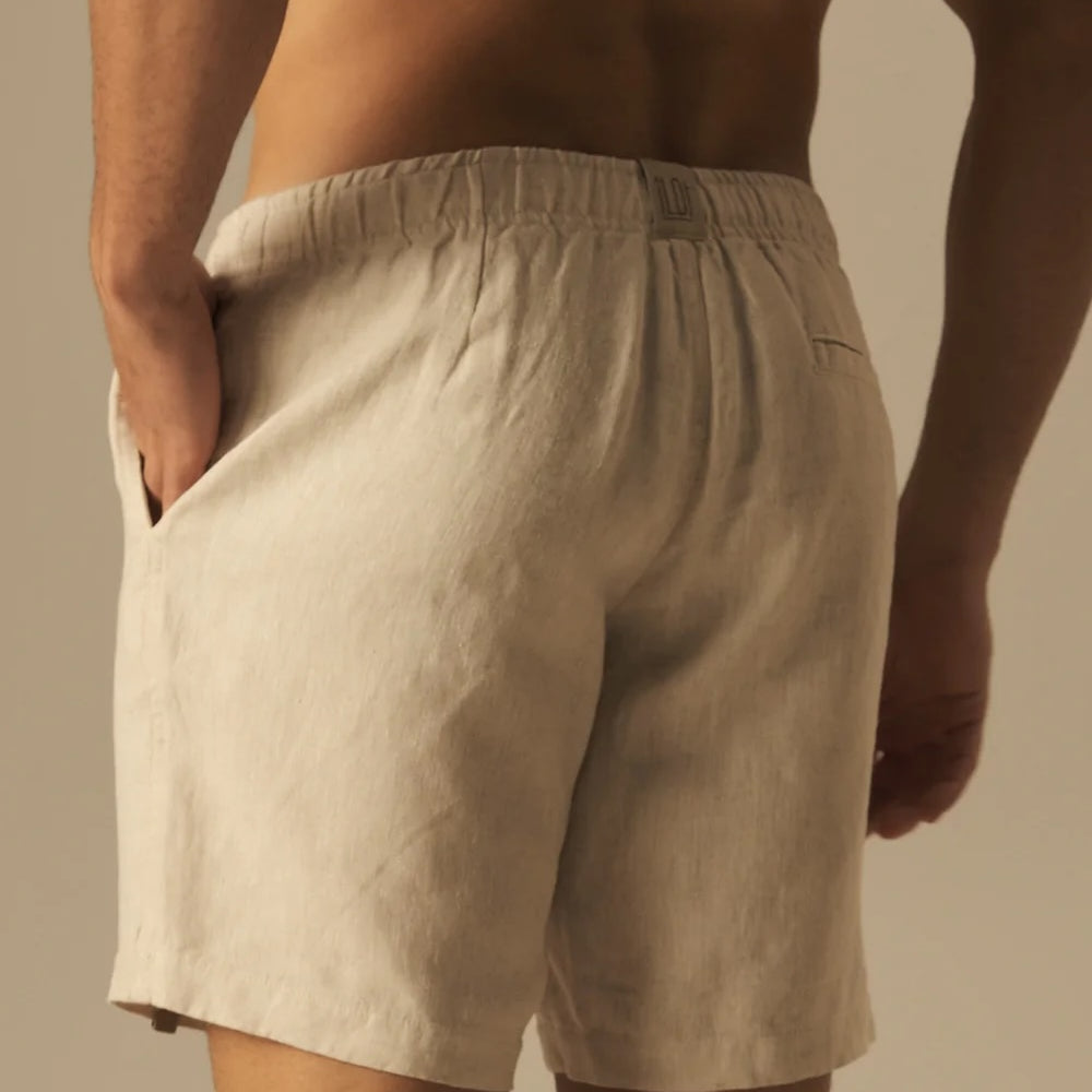 Beige shorts worn by a person against a neutral background.