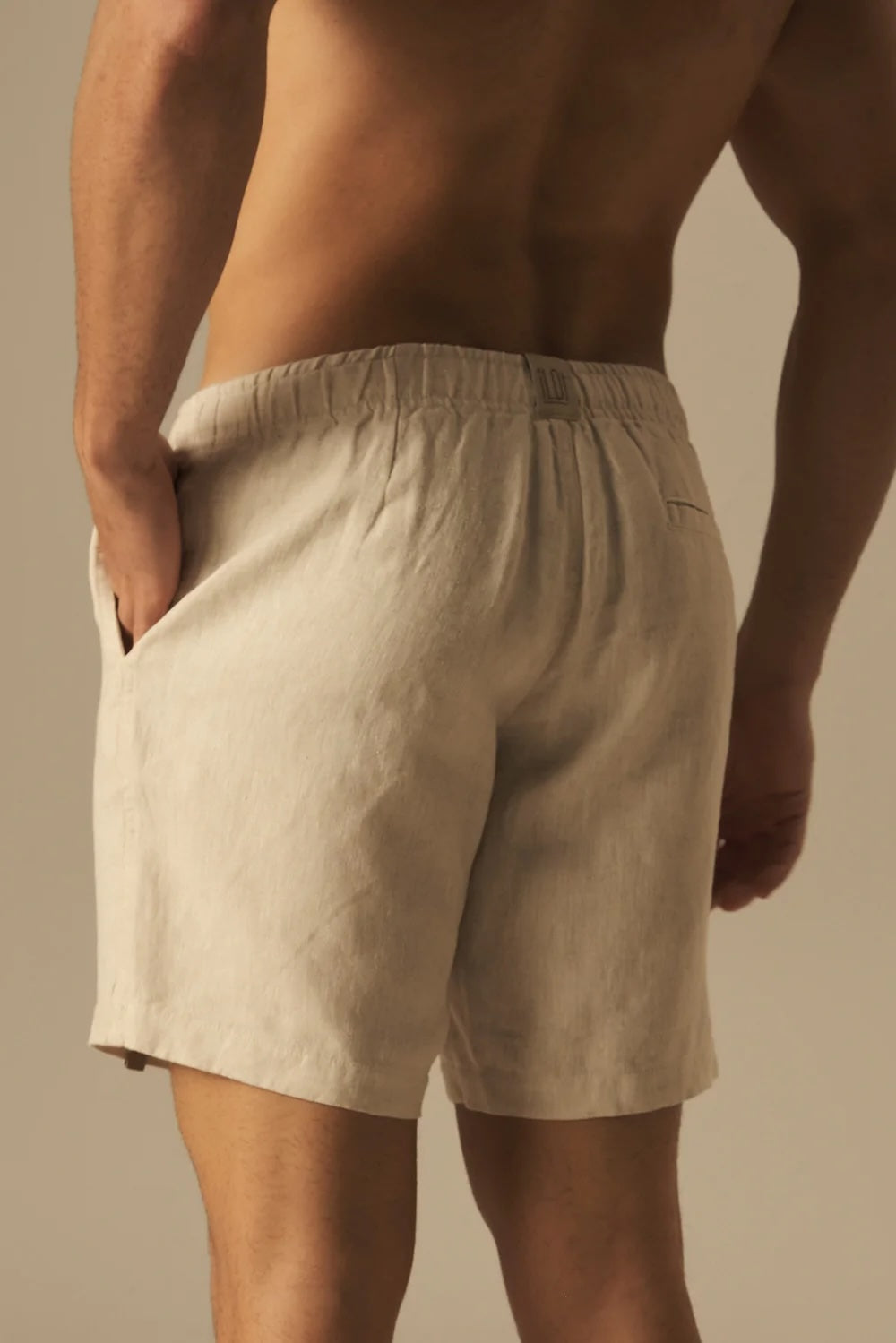 Beige shorts worn by a person against a neutral background.