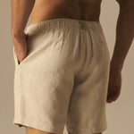 Beige shorts worn by a person against a neutral background.