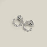 Pair of small sterling silver hoop earrings with bead detail on a neutral background