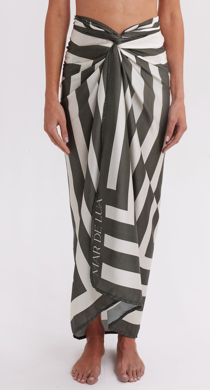 Person wearing a black and white patterned sarong with 'Maruella' branding on a white background