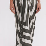Person wearing a black and white patterned sarong with 'Maruella' branding on a white background