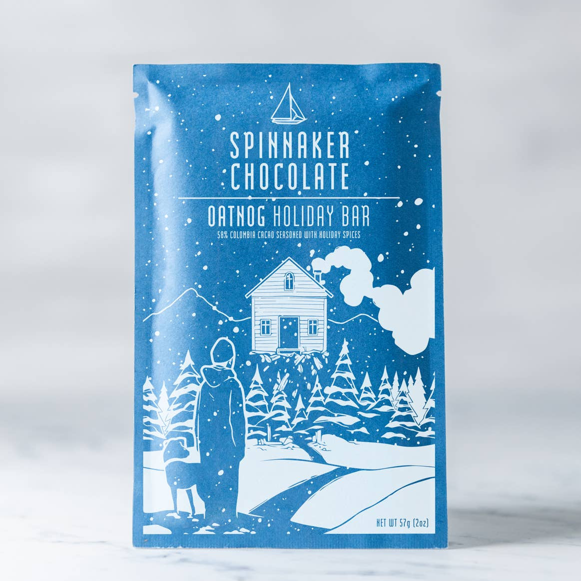 Spinnaker Chocolate Oatdog Holiday Bar packaging with winter scene illustration on a white background.