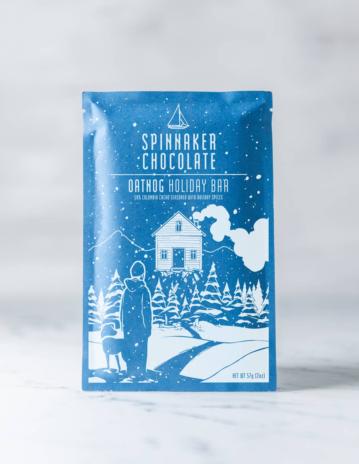 Spinnaker Chocolate Oatdog Holiday Bar packaging with winter scene illustration on a white background.
