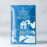 Spinnaker Chocolate Oatdog Holiday Bar packaging with winter scene illustration on a white background.