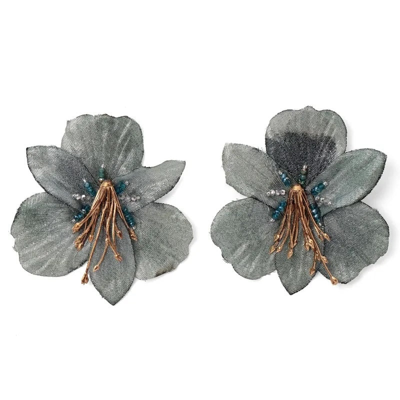Pair of gray floral earrings with gold and blue accents on a white background