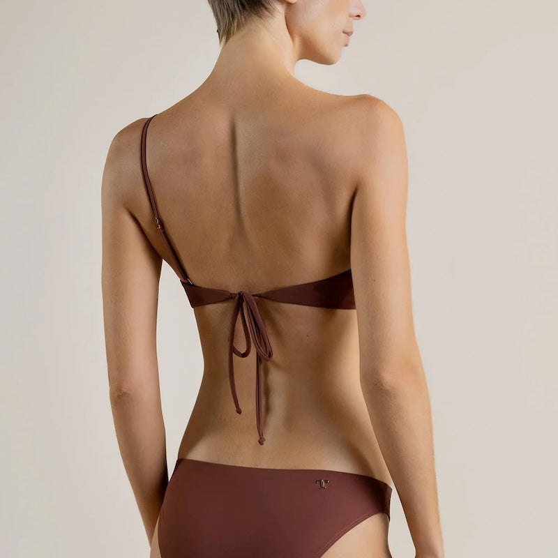 Woman wearing a brown bikini against a plain background.