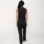 Person wearing a black sleeveless top and pants on a white background