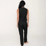 Person wearing a black sleeveless top and pants on a white background