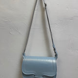 Light blue handbag with a strap on a light gray background