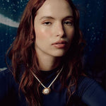 Image of a woman wearing a necklace with the sun on it. The purpose of this image is to highlight the necklace by Pajarolimon jewelry because it is for sale at EVAMAIA Boutique in Studio City, CA.