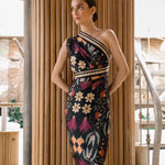 Image of a woman wearing a black sari dress with bright flowers. The purpose of this image is to highlight the dress, which is for sale at EVAMAIA boutique in Studio City, CA.