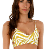 Woman wearing a bikini top with white and yellow animal print. She's standing against a white background. The purpose of this image is to highlight the swimsuit.