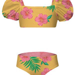 Yellow bikini top and bottom with pink floral and green leaf pattern on a white background