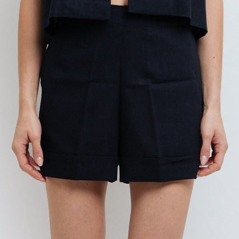 Close up of a woman wearing the Claudette Navy Blue Shorts by Mar de Lua with button-front detail. Made in Colombia, available at EVAMAIA Boutique, Studio City, Los Angeles, CA.