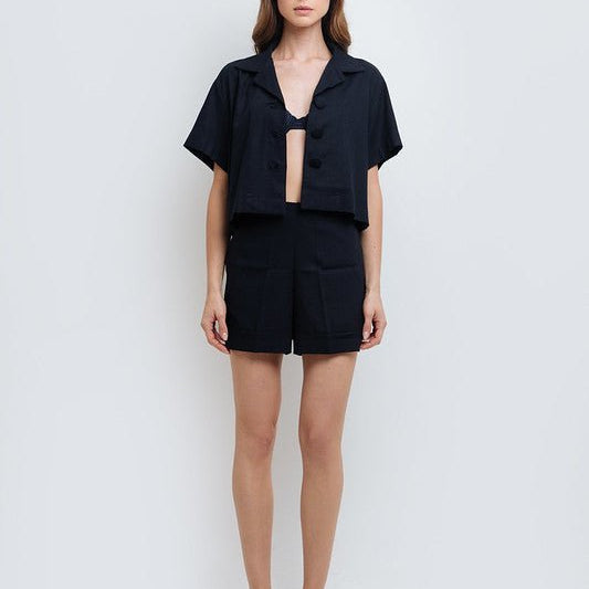 Woman wearing Claudette Navy Blue Shorts and Arlet Crop Shirt by Mar de Lua with button-front detail. Made in Colombia, available at EVAMAIA Boutique, Studio City, Los Angeles, CA.