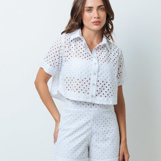 A woman is shown from the back wearing white shorts with small holes and a matching white top.