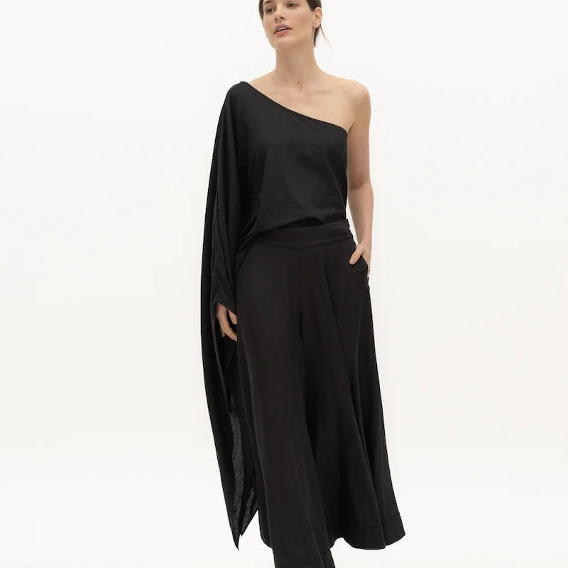 Image of a woman wearing black pants and a matching top on a white background. The purpose of this image is to highlight the pants by NAOS because we sell them at EVAMAIA Boutique in Studio City, CA and online.