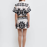 Back of a model wearing a stylish black and white abstract print shirt and skirt set made from high-quality polyester with a linen-like feel