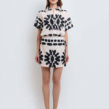 Model wearing a stylish black and white abstract print shirt and skirt set made from high-quality polyester with a linen-like feel.