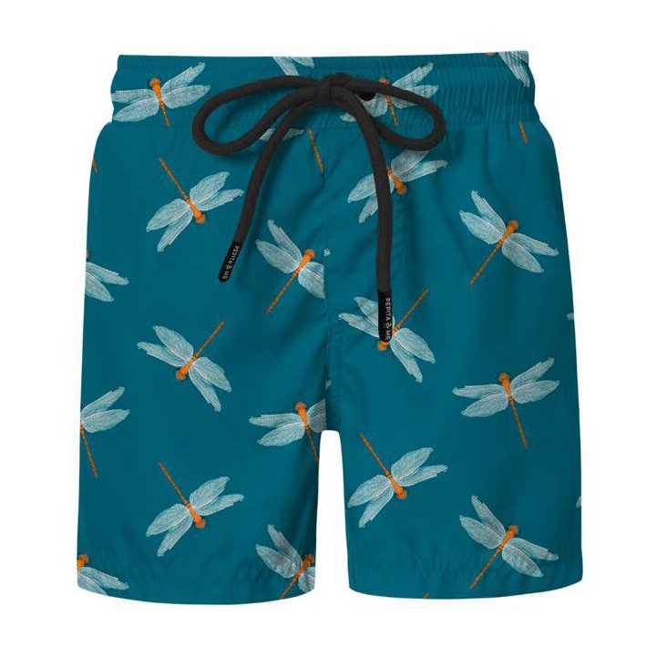 Swim trunks for boys with a teal fabric and cute dragonfly print. Against a white background. The purpose of this image is to show the trunks, which are for sale at EVAMAIA Boutique. 