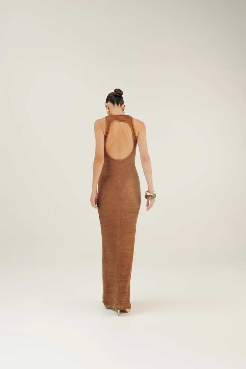 Woman wearing a brown crochet open-back dress on a white background.