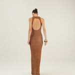 Woman wearing a brown crochet open-back dress on a white background.