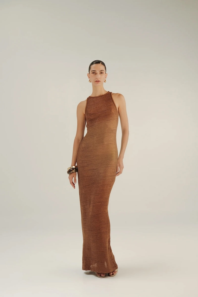 Woman wearing a brown crochet dress on a white background.