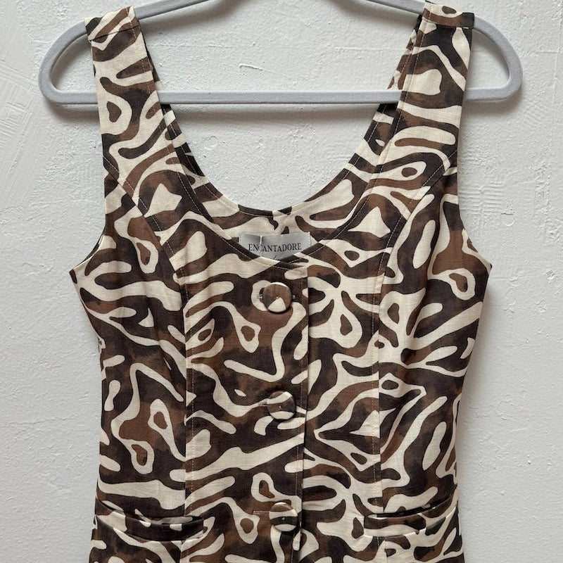 Image of a brown vest hanging on a hanger at a boutique. It's against a greyish white wall. 