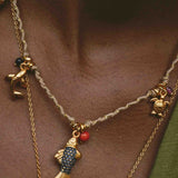 Necklace with fish charm and gold chain on a person's neck