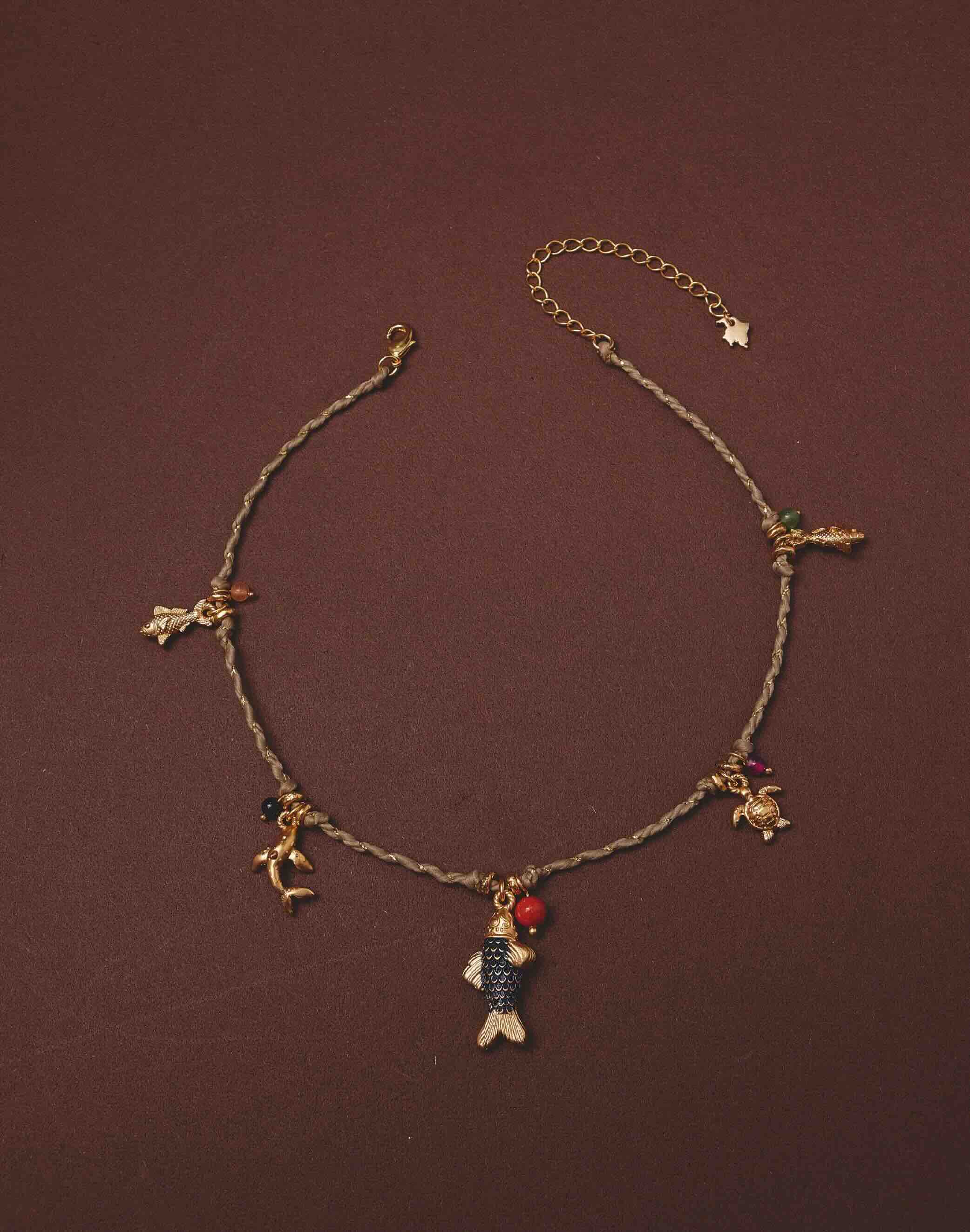 Necklace with various charms on a brown background