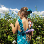Little girl with her hair up in a ponytail wearing this cute one piece swimsuit.
