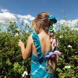 Little girl with her hair up in a ponytail wearing this cute one piece swimsuit.