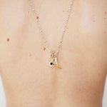 Necklace with a small pendant on a person's neck