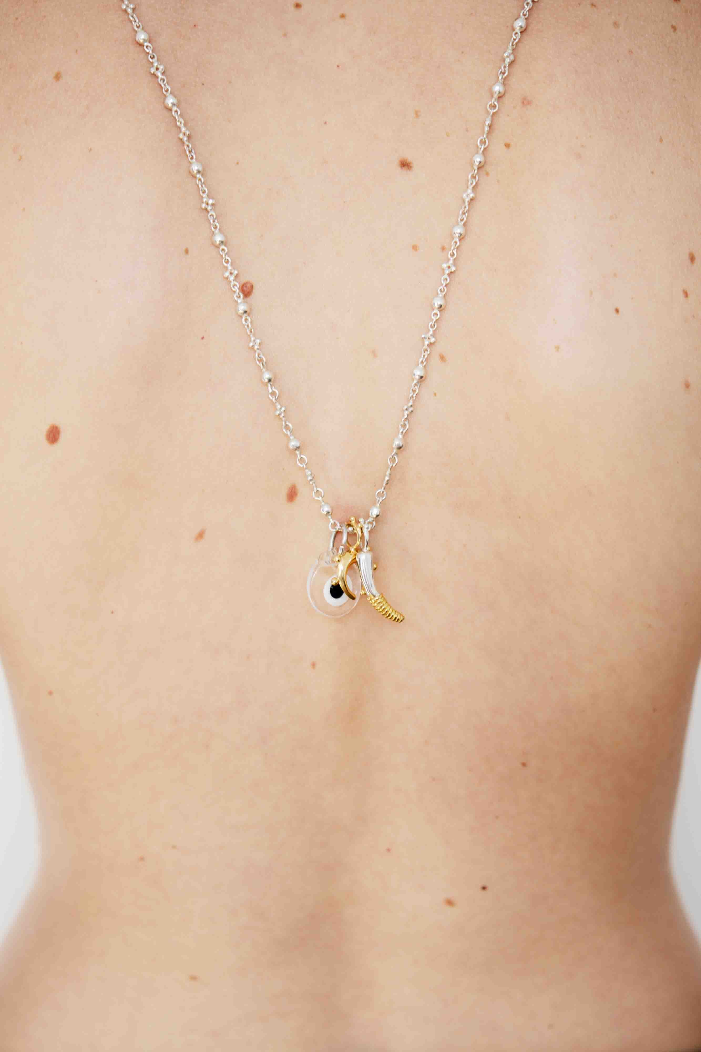 Necklace with a small pendant on a person's neck