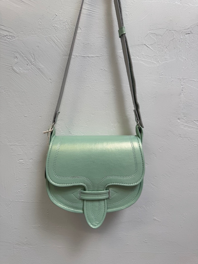 Mint green handbag with a strap on a light gray background