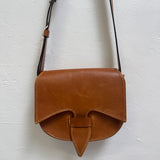 Brown leather crossbody bag on a light gray background